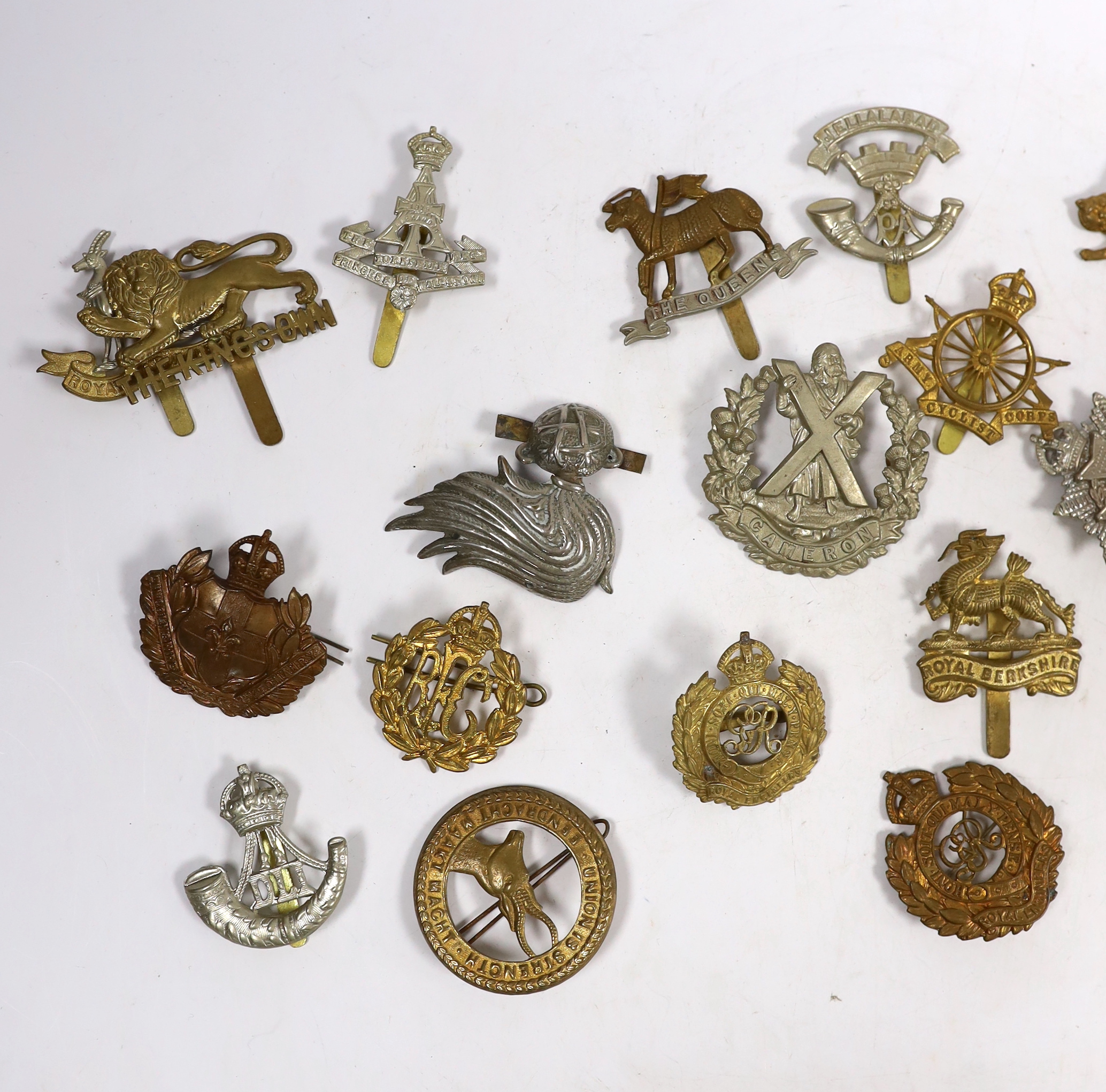 Twenty-five military cap badges including Royal Engineers, The Kings Own, Royal Warwickshire, North Stafford, Royal Berkshire, The Border Regiment, Army Cyclist Corps, South Staffordshire, Middlesex, Cameron, Hampshire,